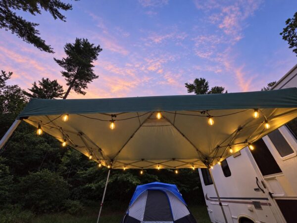 String lights hanging around a camping canopy at dusk, showing the hooks in use. Hooks only; lights and canopy not included.