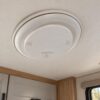Illustrative RV interior mockup showing an AC vent cover. Not a photograph of a verified installation. Vent and RV not included.